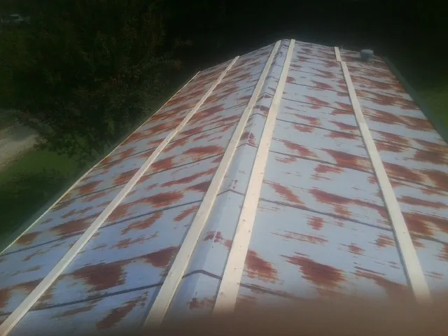 Rusted metal roof panels with new wood purlins before replacement — Storm Damage Roof Repair in Grapeville by Roofing Brothers