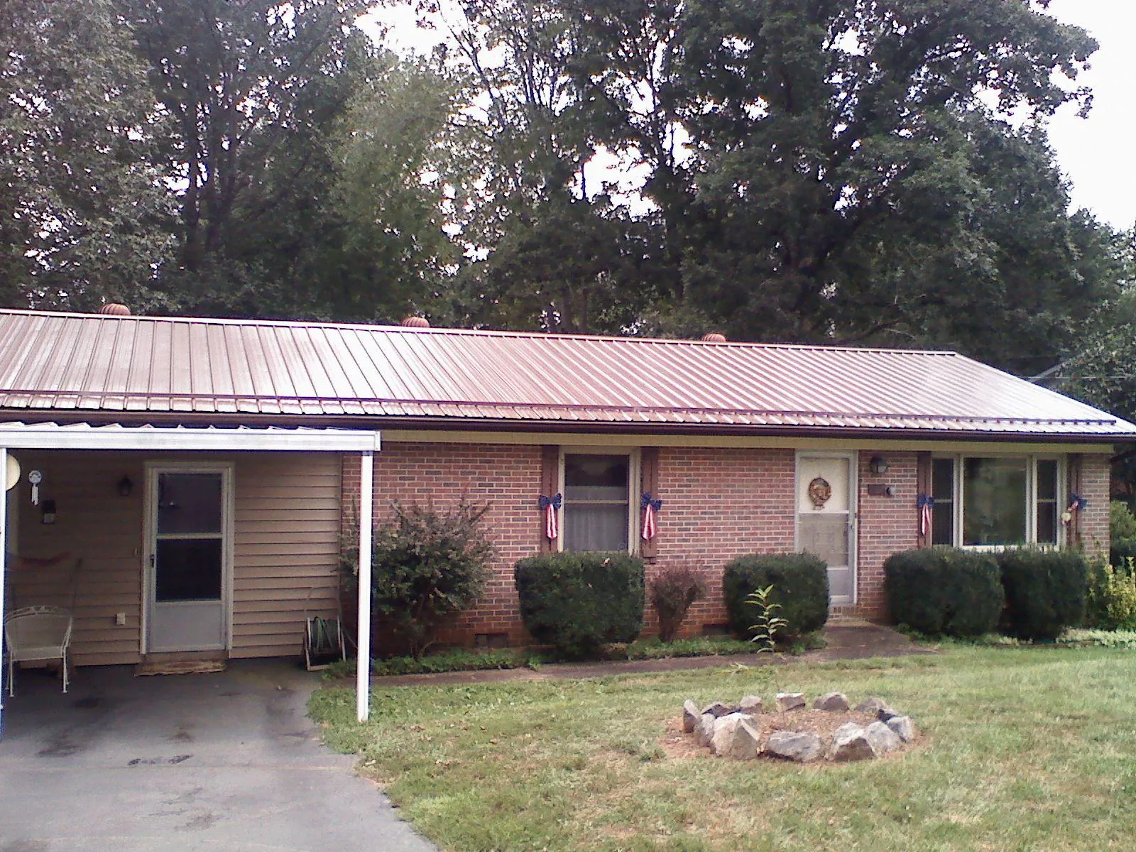 Bronze metal roof and carport on a brick ranch home — Roof Repair work by our crew in Grapeville